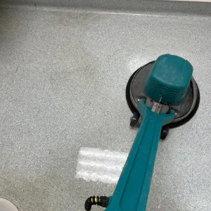 Floor machine deep-cleaning a commercial floor
