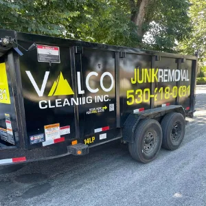 Valco's black dump trailer with yellow junk removal lettering and phone number